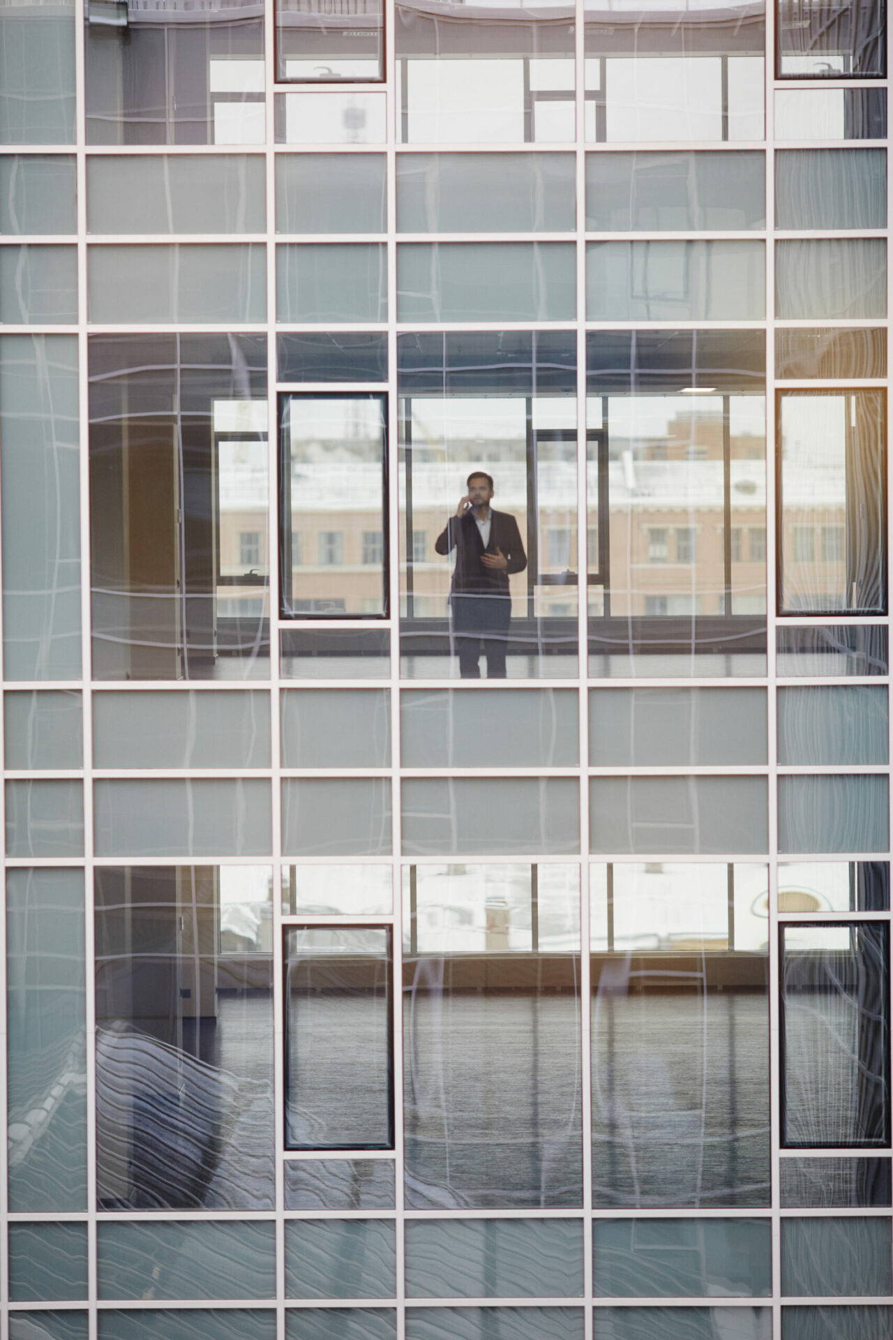 A business man standing in front of windows in a skyscraper